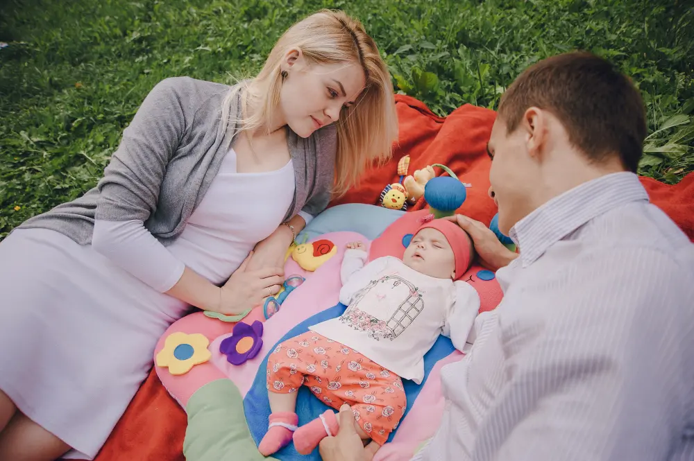 des parents regardant leur bébé faire la sieste